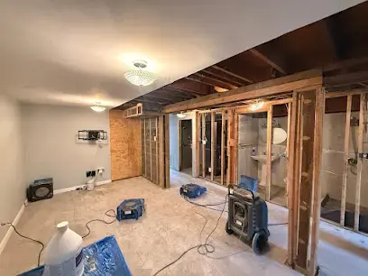 Opened walls and drying equipment in a water-damaged Jamaica, NY room